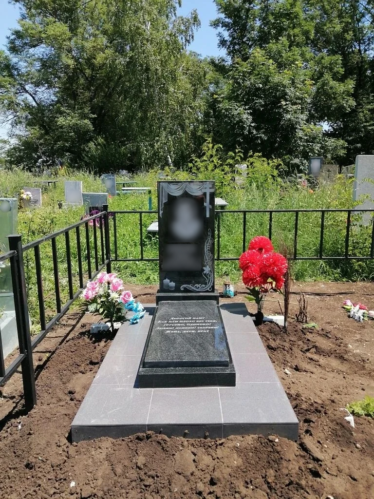 Памятник с надгробной плитой и тёмной площадкой